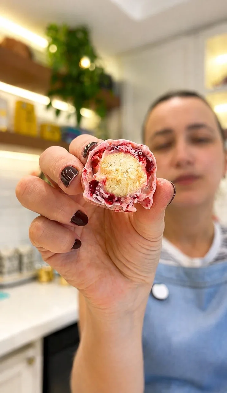 Mari Molina segurando o biscoito do amor cortado, mostrando o miolo